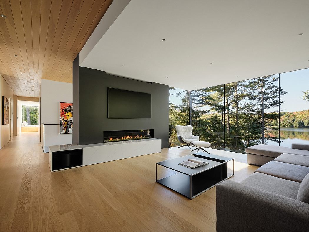 Sleek, modern interior with floor-to-ceiling windows, wood paneled ceiling, and minimalist fireplace.