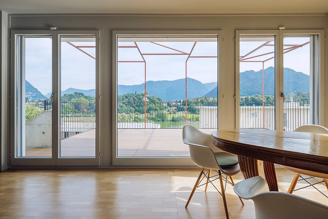 Spacious room with large windows offering panoramic views of mountainous landscape.