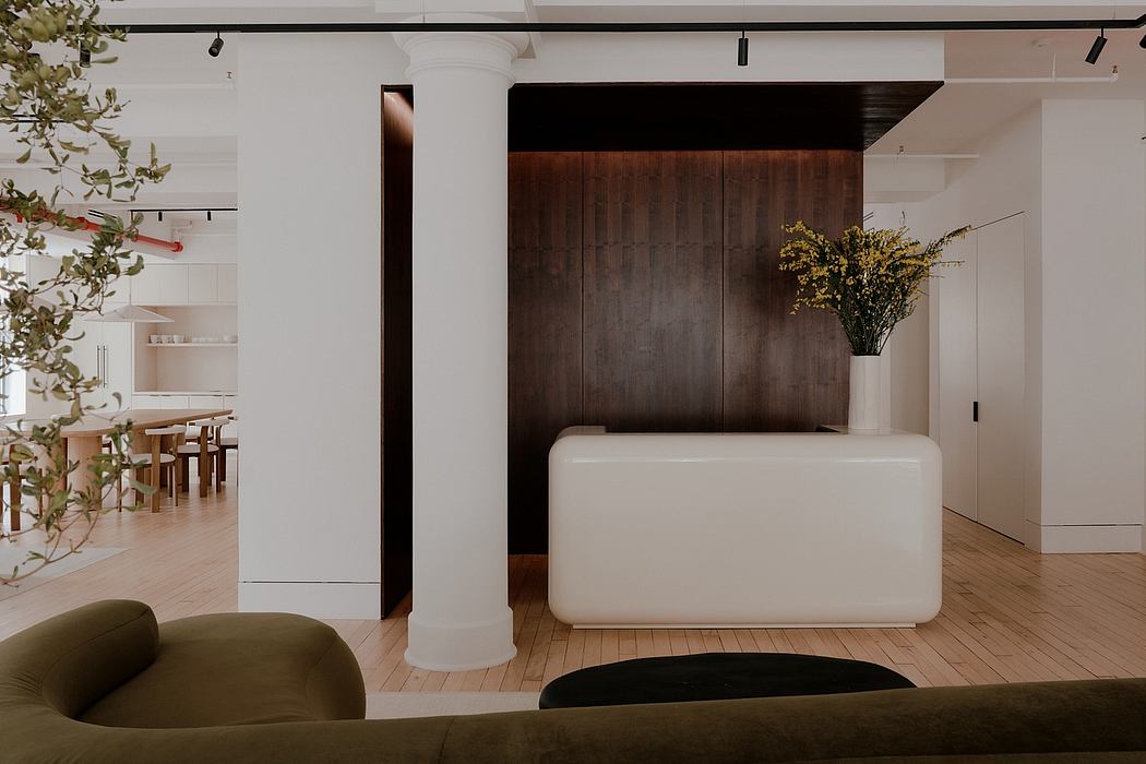 Minimalist, modern interior design with wooden paneling, white furniture, and potted plants.