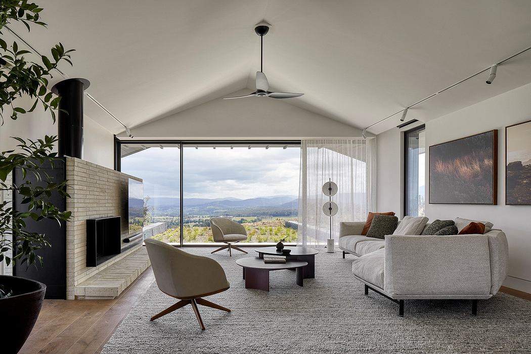 Expansive living room with large windows, cozy furnishings, and scenic mountain views.