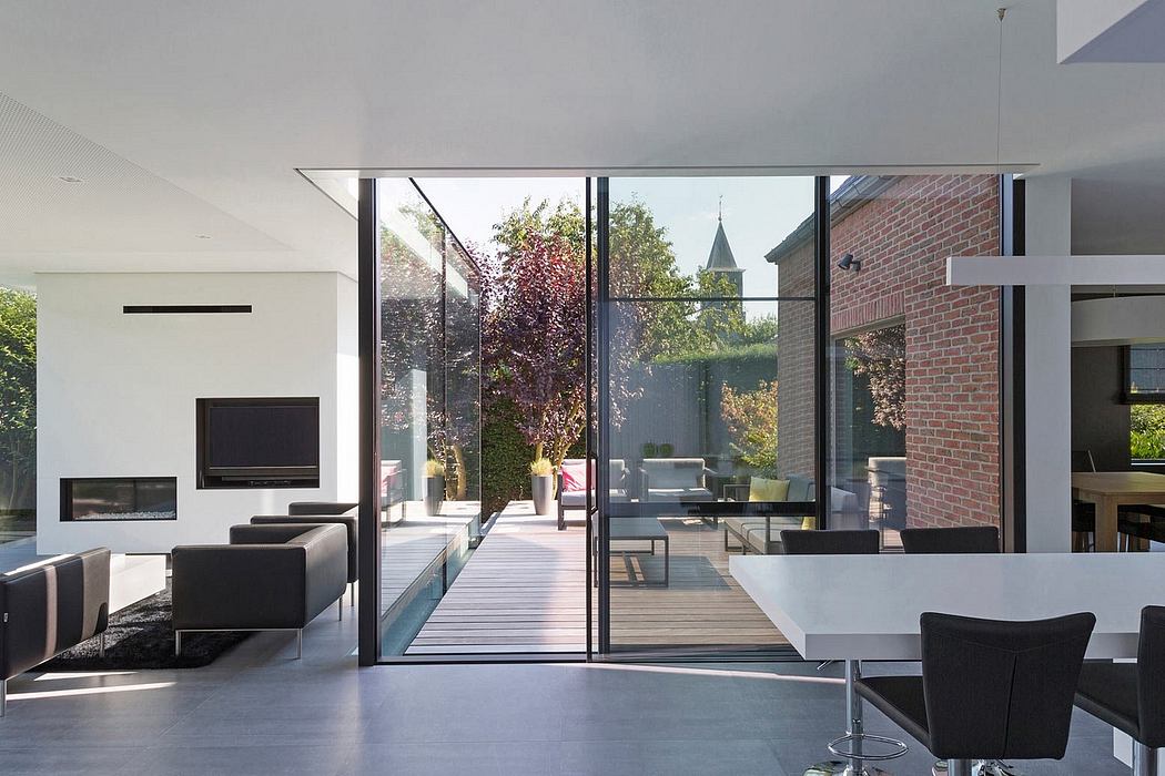 Modern glass and brick home with seamless indoor-outdoor flow and serene garden view.