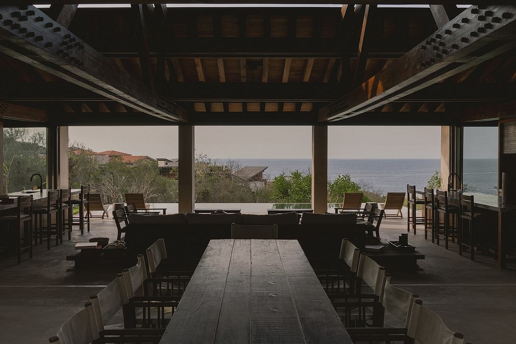 Rustic wooden beams, panoramic ocean views, and minimalist furnishings create a serene atmosphere.