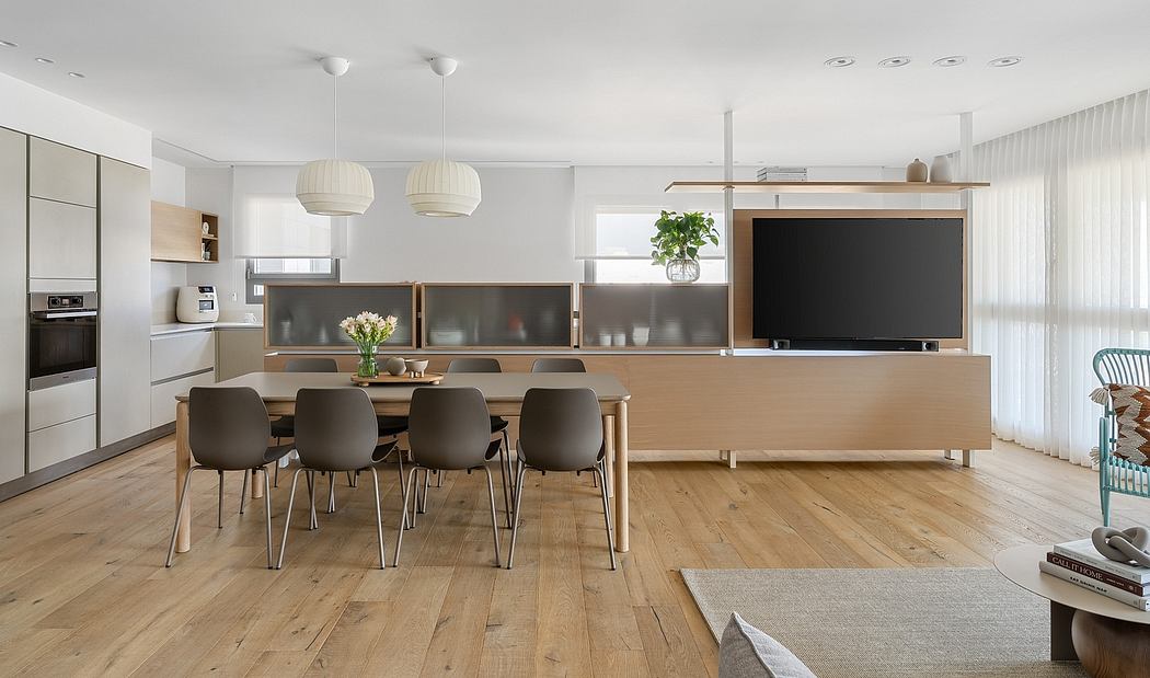 Modern, open-plan living space with wooden floors, minimalist furniture, and pendant lighting.