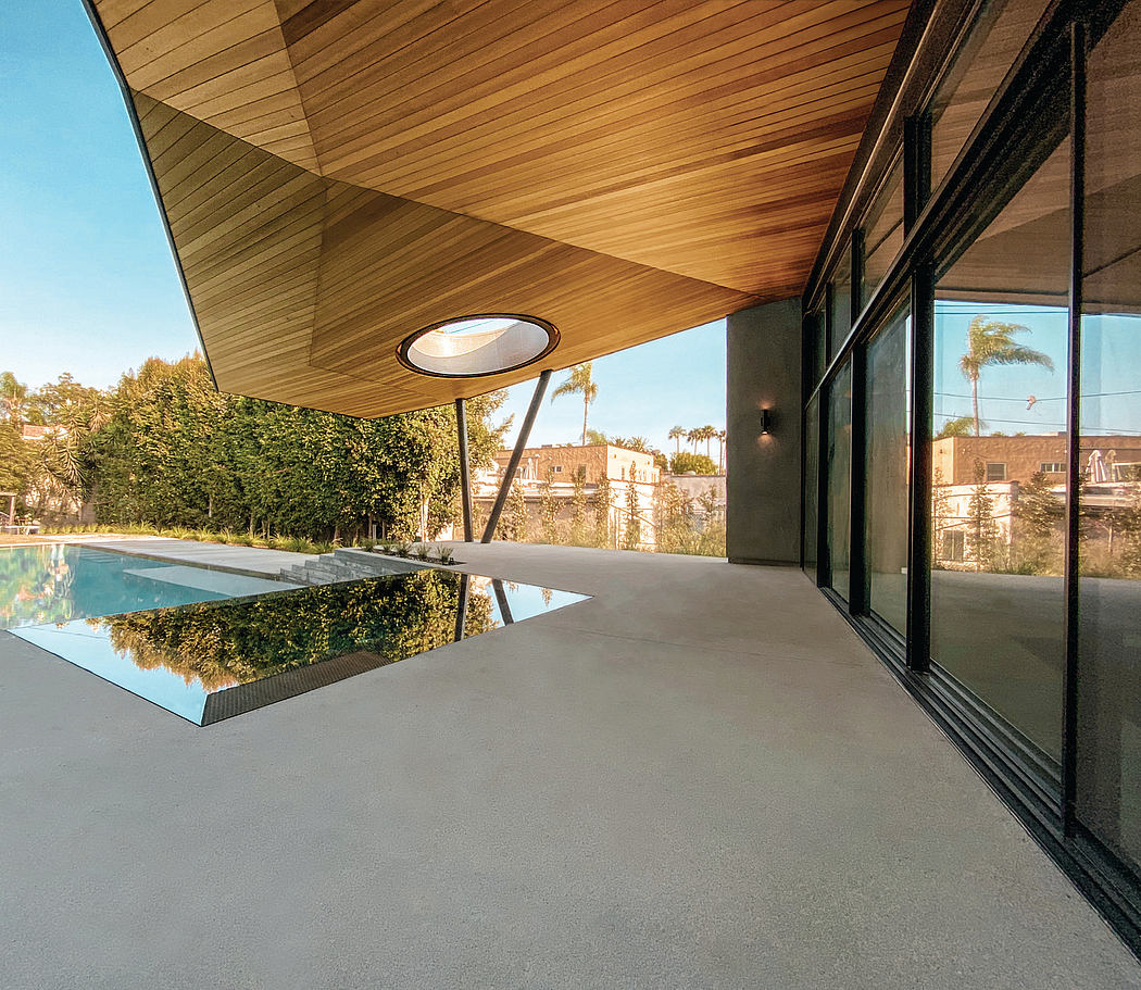 The image depicts a modern architectural design with a wooden ceiling, large glass windows, and a pool reflecting the surrounding landscape.