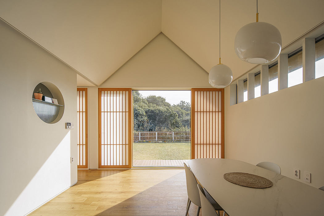 A spacious, modern interior with vaulted ceilings, wooden accents, and large windows offering a scenic view.