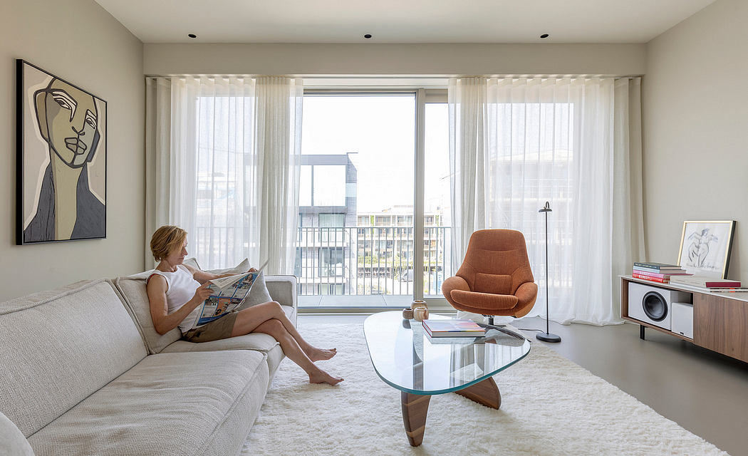 Spacious, modern living room with floor-to-ceiling windows, plush sofa, and statement glass coffee table.