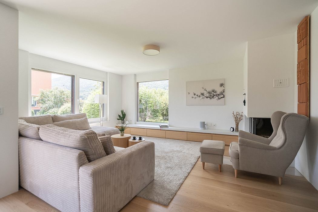 Bright, modern living room with large windows, sleek wood-paneled furniture, and plush seating.