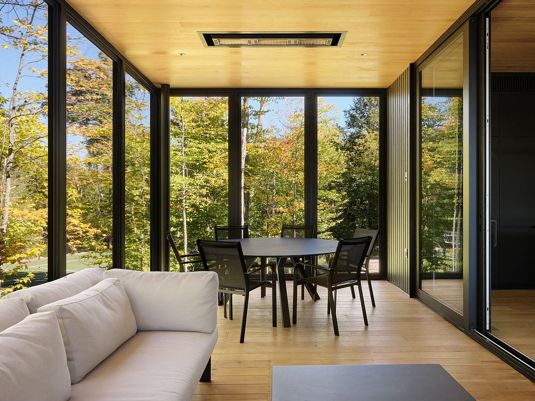 Panoramic windows frame a modern, open-concept living space with nature views.