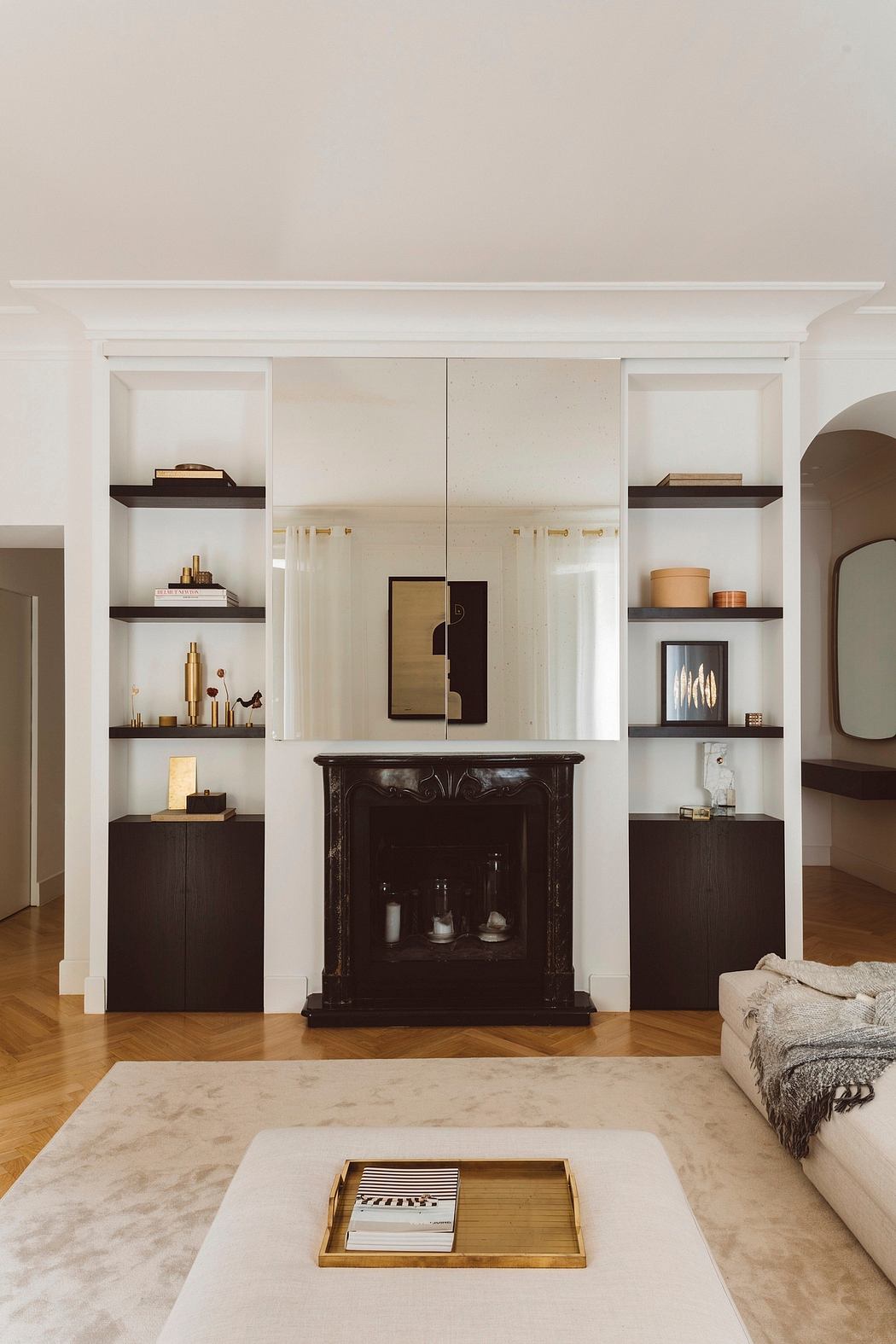 A cozy living room with built-in shelves, a dark antique cabinet, and a marble-topped coffee table.