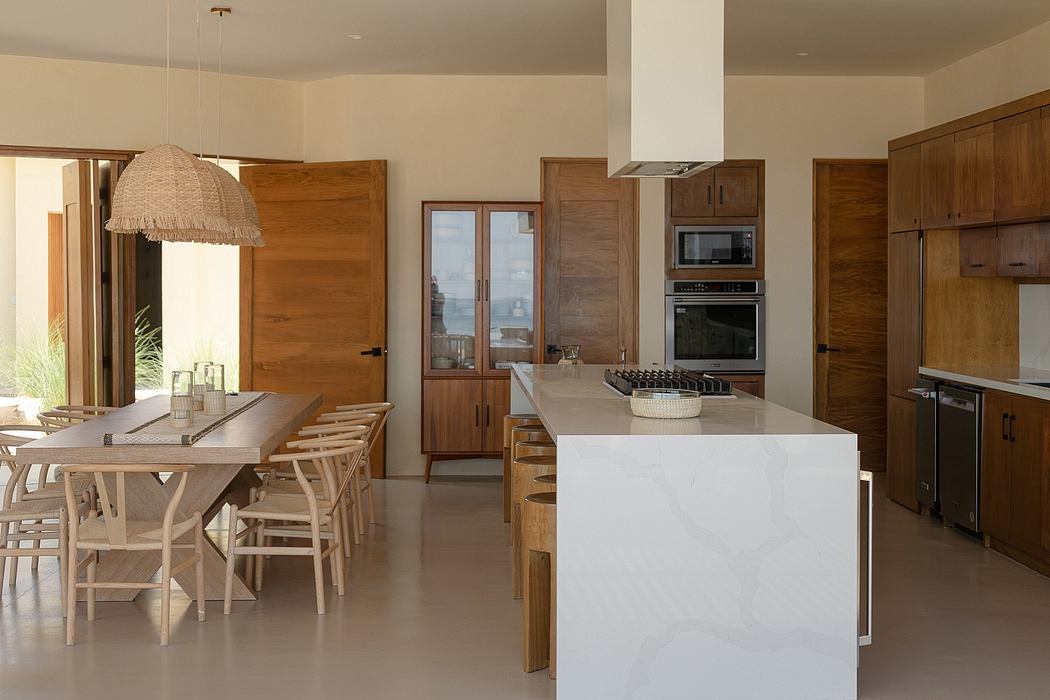 A spacious, modern kitchen with wooden cabinetry, a white island, and a cozy dining area.