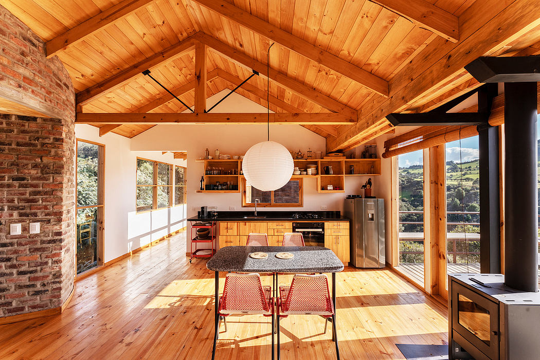Rustic cabin with wooden beams, exposed brick, and open kitchen and dining area.