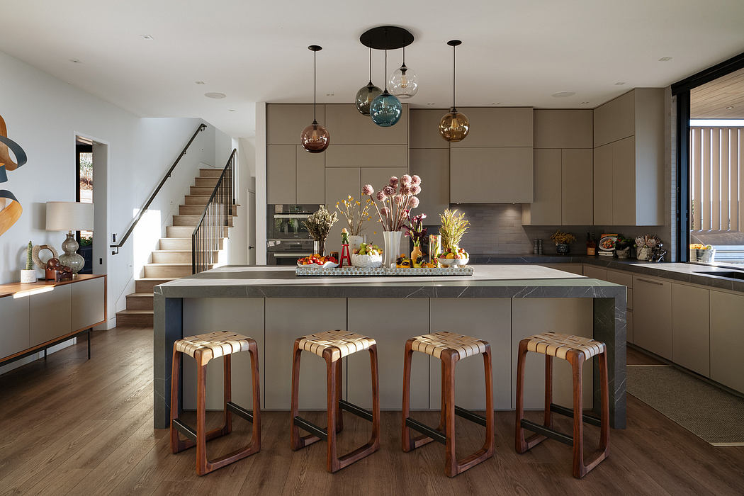Cozy modern kitchen with sleek gray cabinetry, pendant lighting, and wooden bar stools.