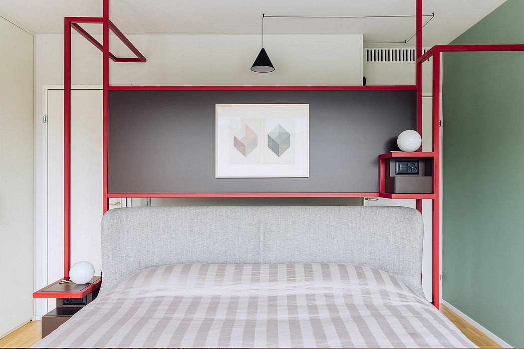 Modern, minimalist bedroom design with red metal accents, geometric artwork, and striped bedding.