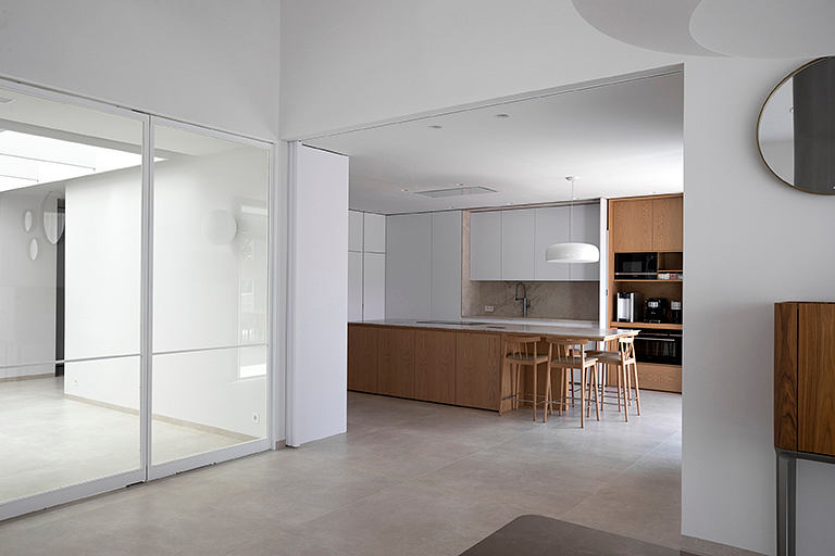 Minimalist open-concept kitchen and living area with wood and concrete accents.
