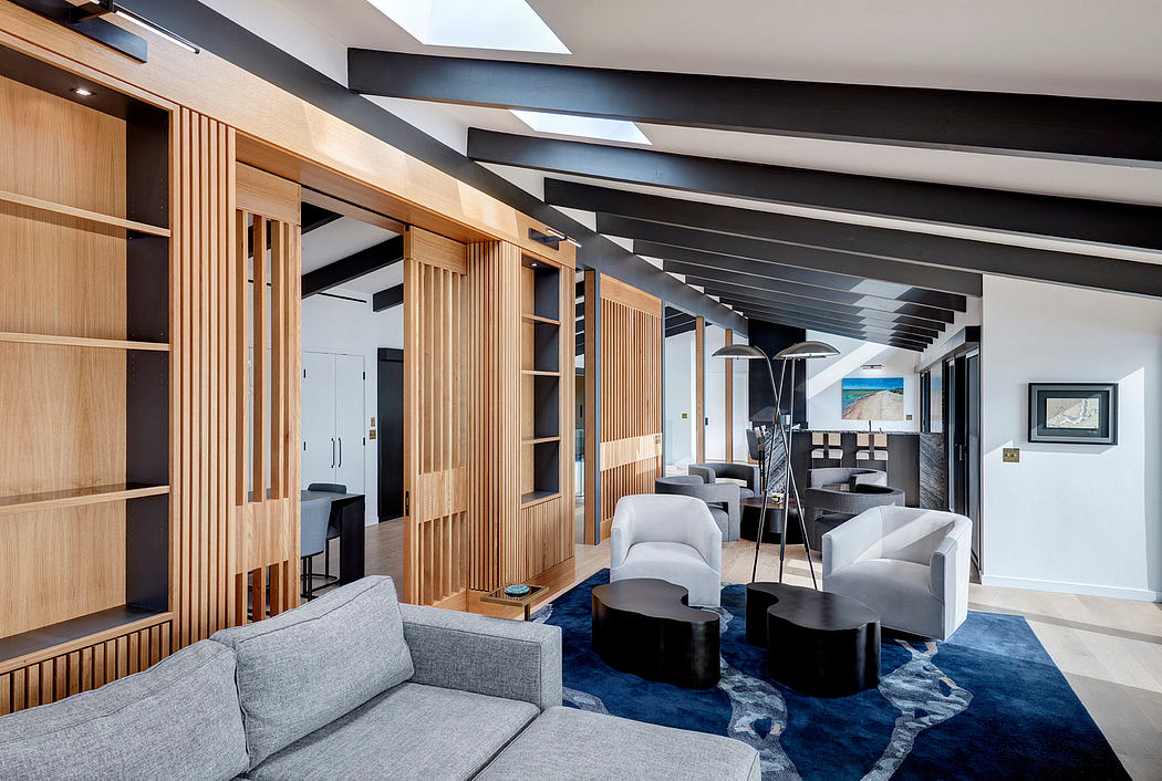 A modern, open-concept living space with wood paneling, skylights, and plush seating.