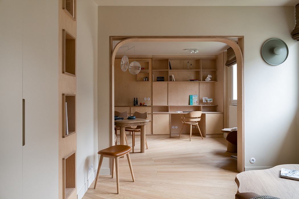 A minimalist, open-plan interior featuring a wooden arched entryway and built-in shelving.