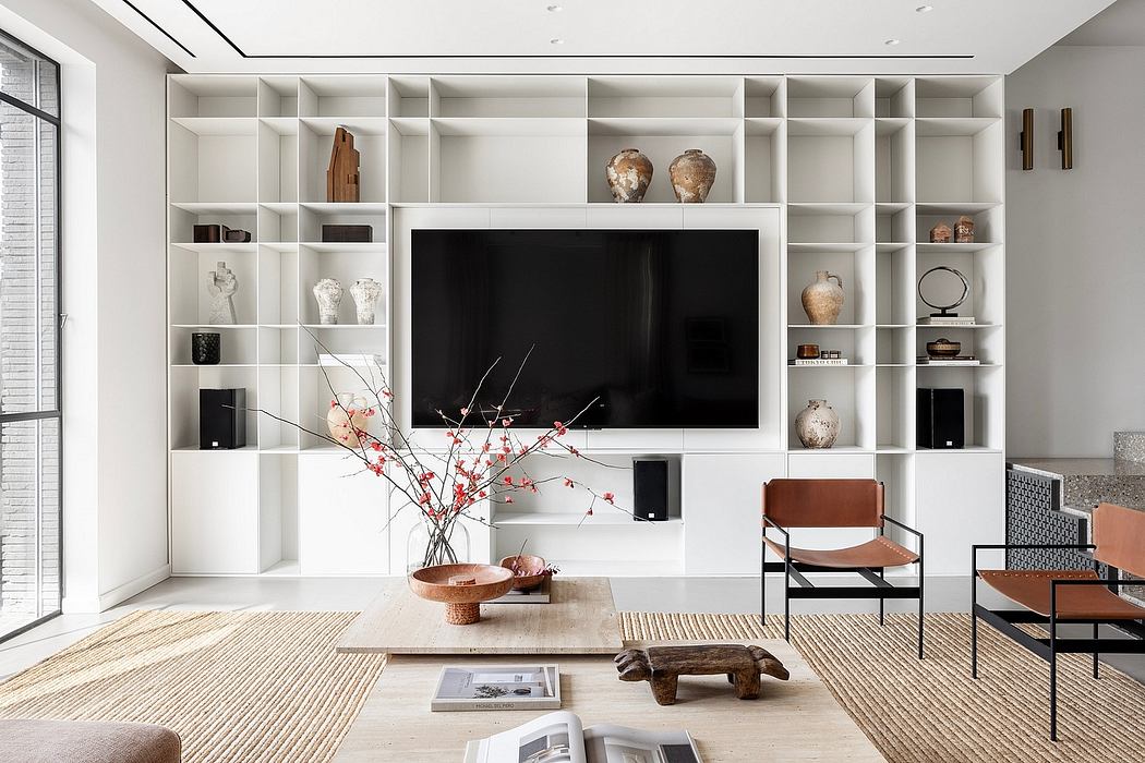 A modern, minimalist living room with a large TV nestled in a built-in shelving unit.