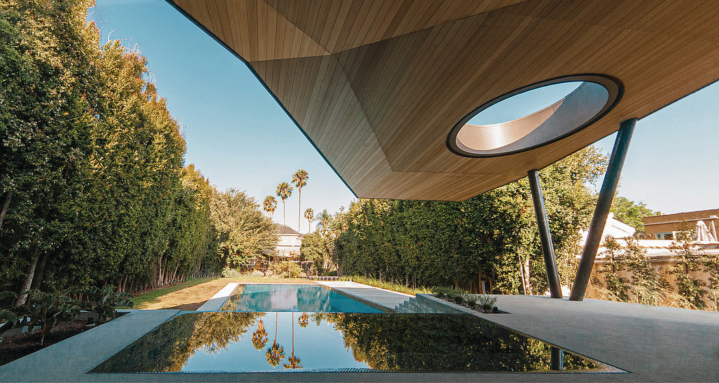 Stunning modern architecture featuring a sleek, geometric pool and lush, tropical landscaping.