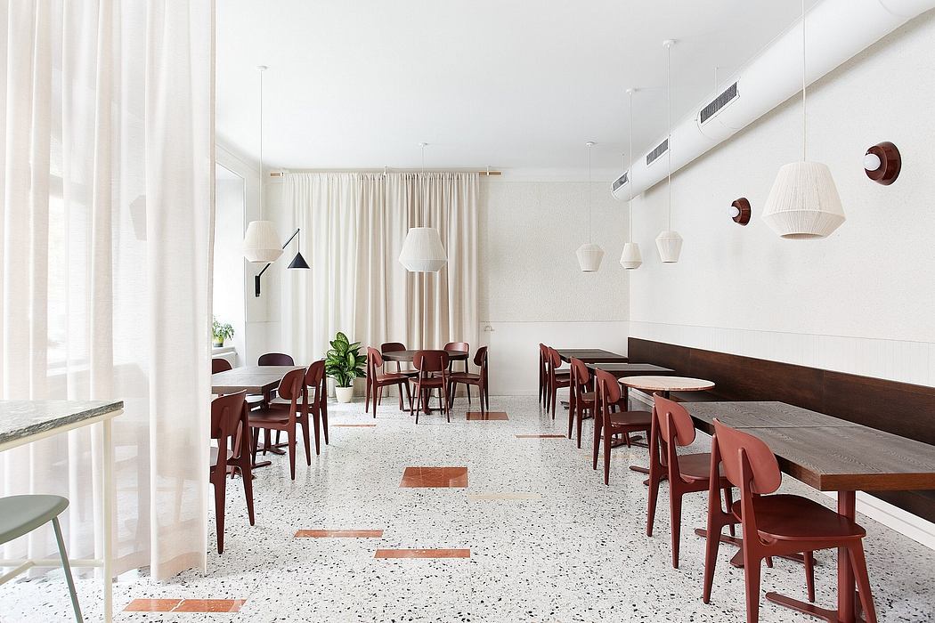 A modern dining space with sleek furniture, white walls, and pendant lighting.