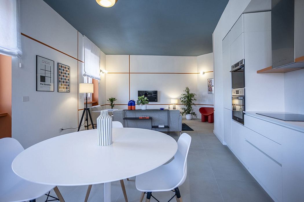 Modern kitchen-living room with a sleek white table, minimalist furniture, and a blue-toned ceiling.