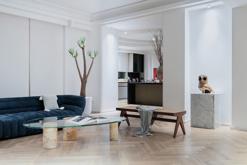 Minimal, modern living room with navy sofa, glass coffee table, and sculptural decor.