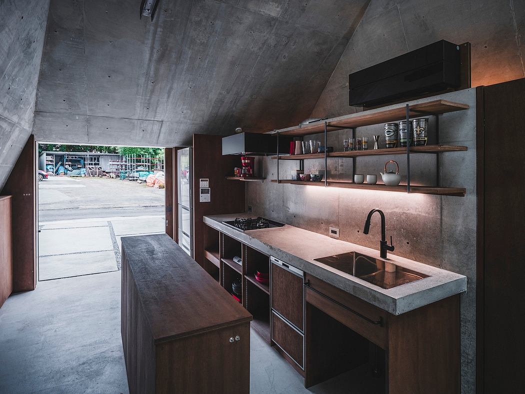 Modern industrial-style kitchen with concrete walls, wooden shelves, and open layout.