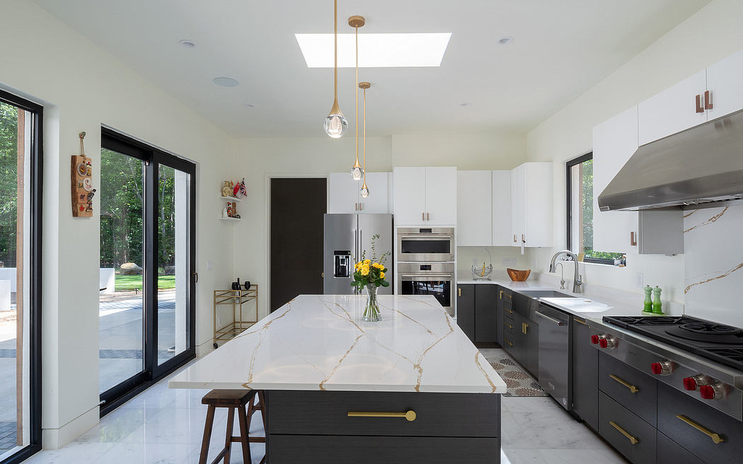 Sleek modern kitchen with marble countertops, black cabinetry, and large windows.