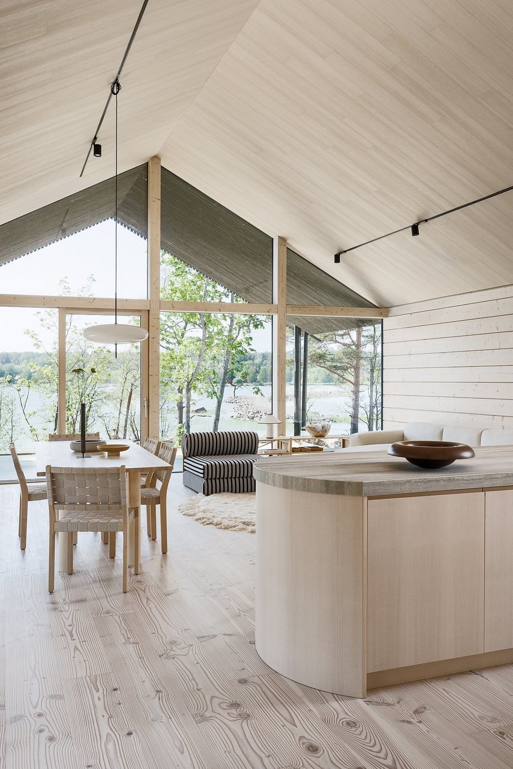 Spacious open-concept interior with wooden accents, large windows, and minimalist furnishings.