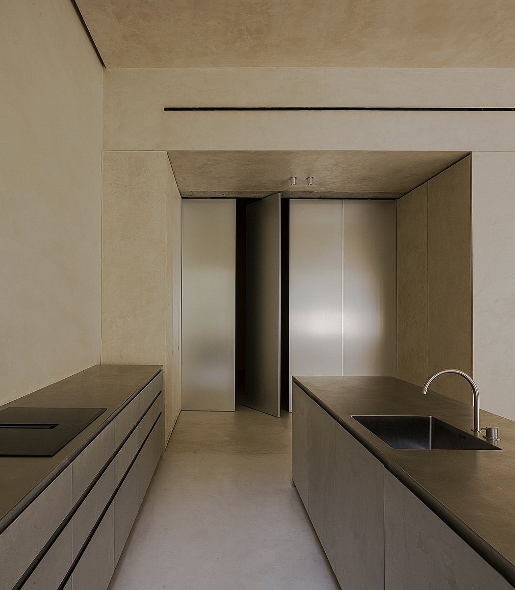 Minimalist kitchen design with clean lines, monochromatic palette, and recessed handles.