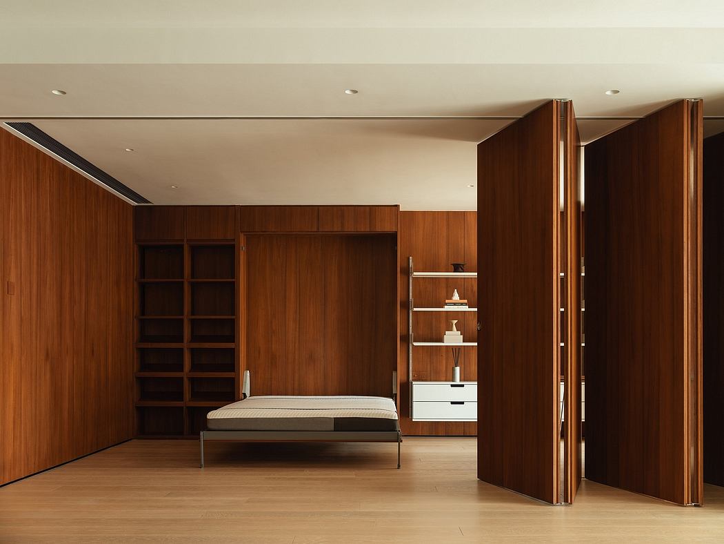 A spacious, modern bedroom with clean lines, warm wood panels, and custom shelving.