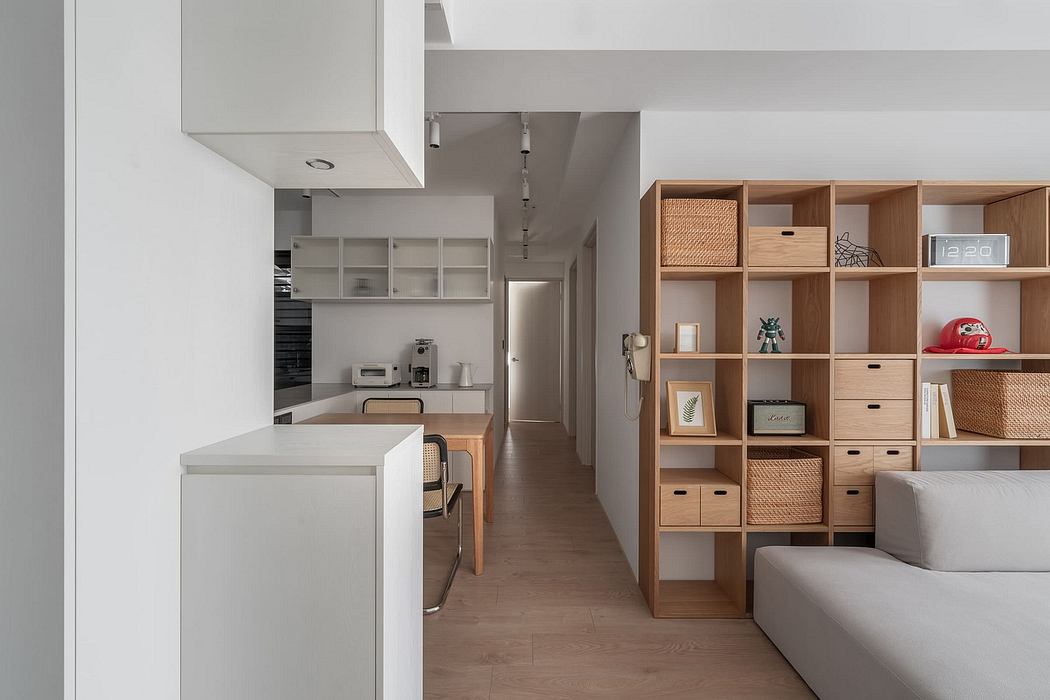 Compact apartment with minimalist kitchen, custom storage unit, and modern furnishings.