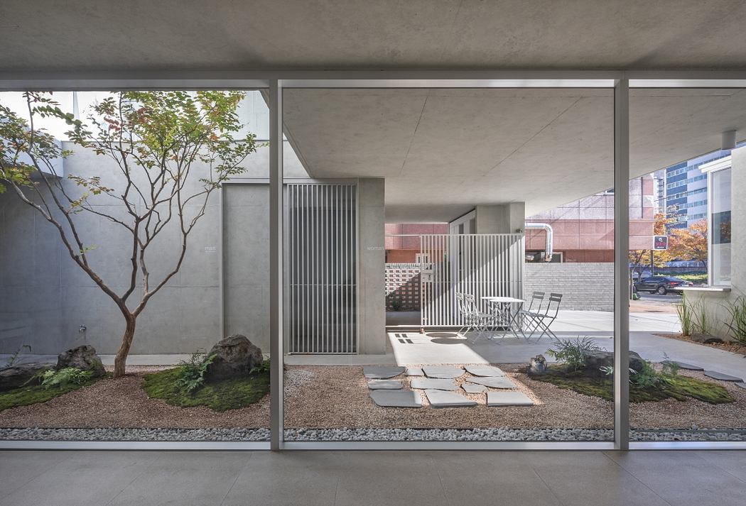 Minimalist architectural design with concrete, metal, and greenery elements.
