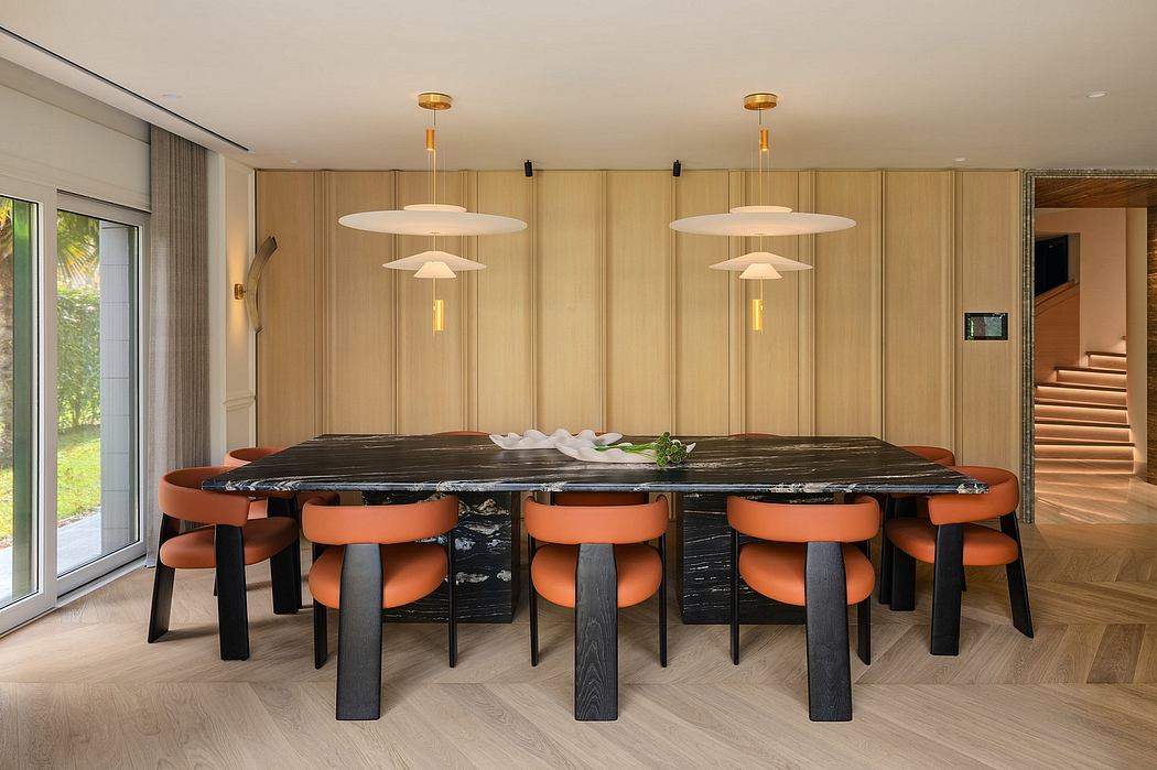 Warm wood paneling, sleek lighting, and a bold marble dining table create a refined space.