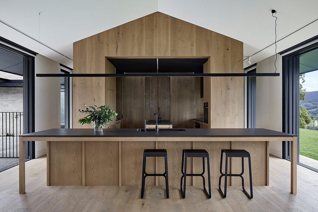 Sleek wood-paneled kitchen with modern bar stools, steel accents, and expansive views.