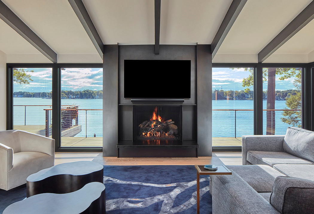 Modern living room with fireplace, large windows overlooking a lake, and contemporary furnishings.