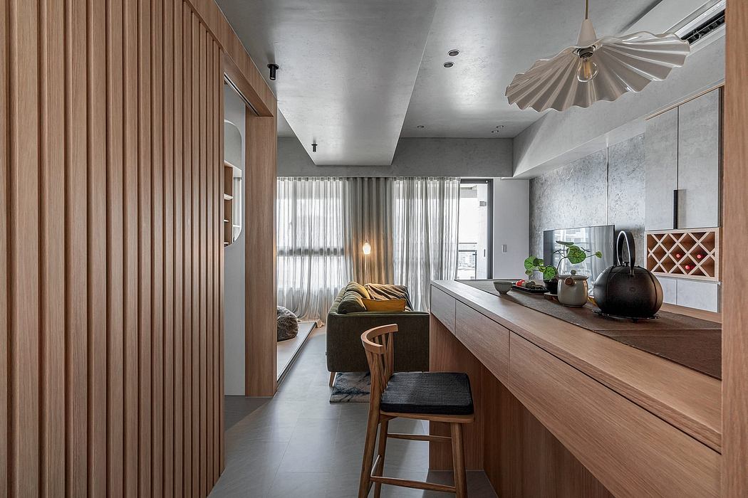 Warm-toned wooden panels, sleek kitchen counter, and stylish lighting create a modern ambiance.