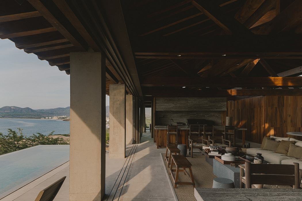 Rustic wooden beams, concrete walls, and a panoramic view overlooking the water.