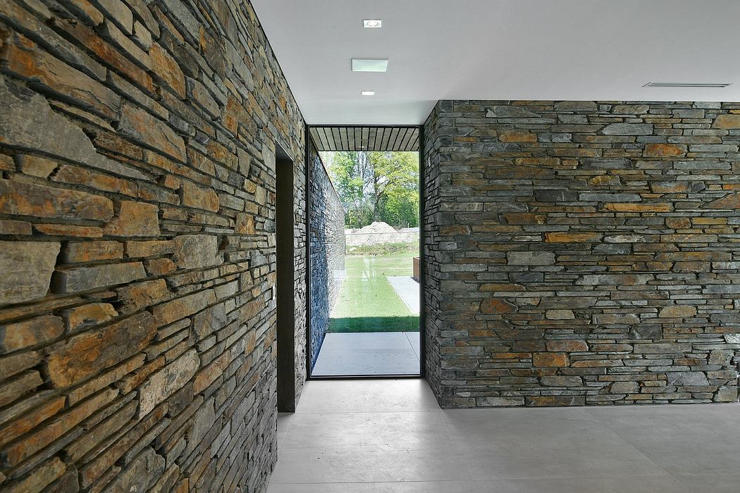 Stone walls with narrow entryway frame lush outdoor scenery beyond.