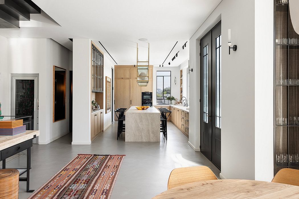 Sleek, modern kitchen with concrete floors, light wood cabinetry, and steel appliances.