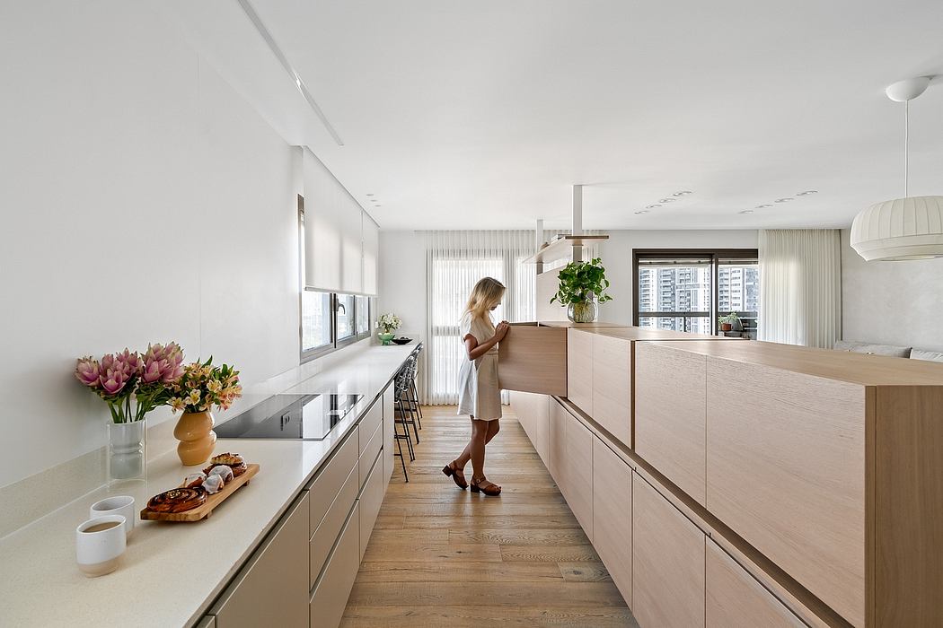 Bright, minimalist kitchen with natural wood cabinetry and a large window overlooking the city.