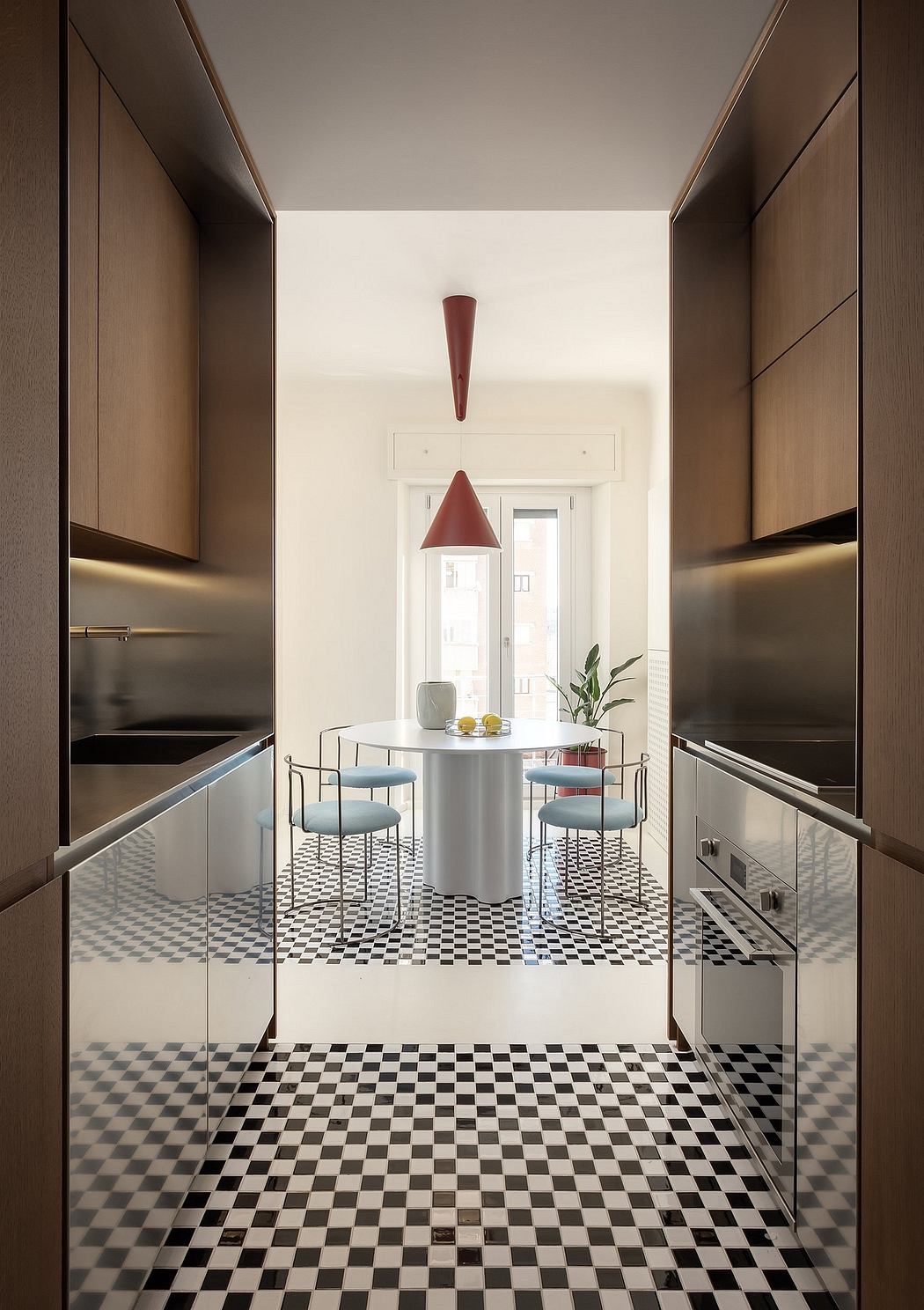 A modern kitchen with sleek cabinets, a minimalist dining table, and a striking black-and-white checkered floor.