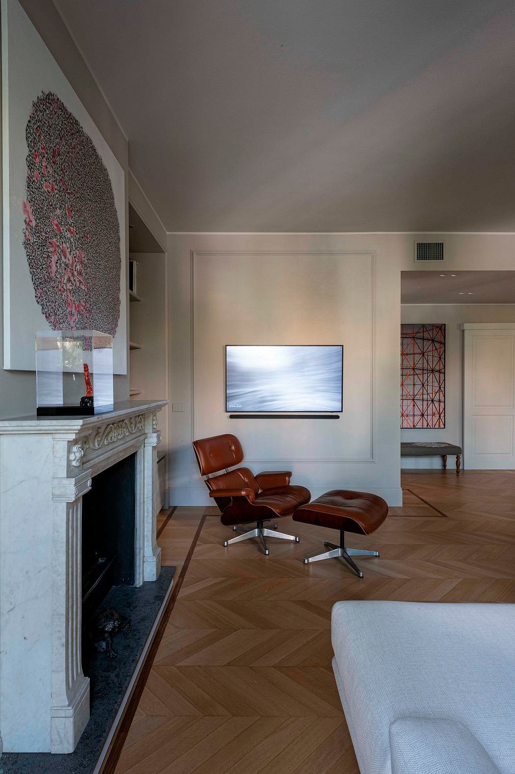 A modern, minimalist living room with a fireplace, leather chairs, and a TV on the wall.