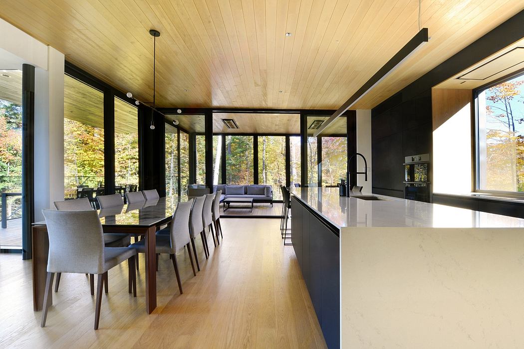 A modern, open-concept home interior with a wooden ceiling, large windows, and sleek furnishings.