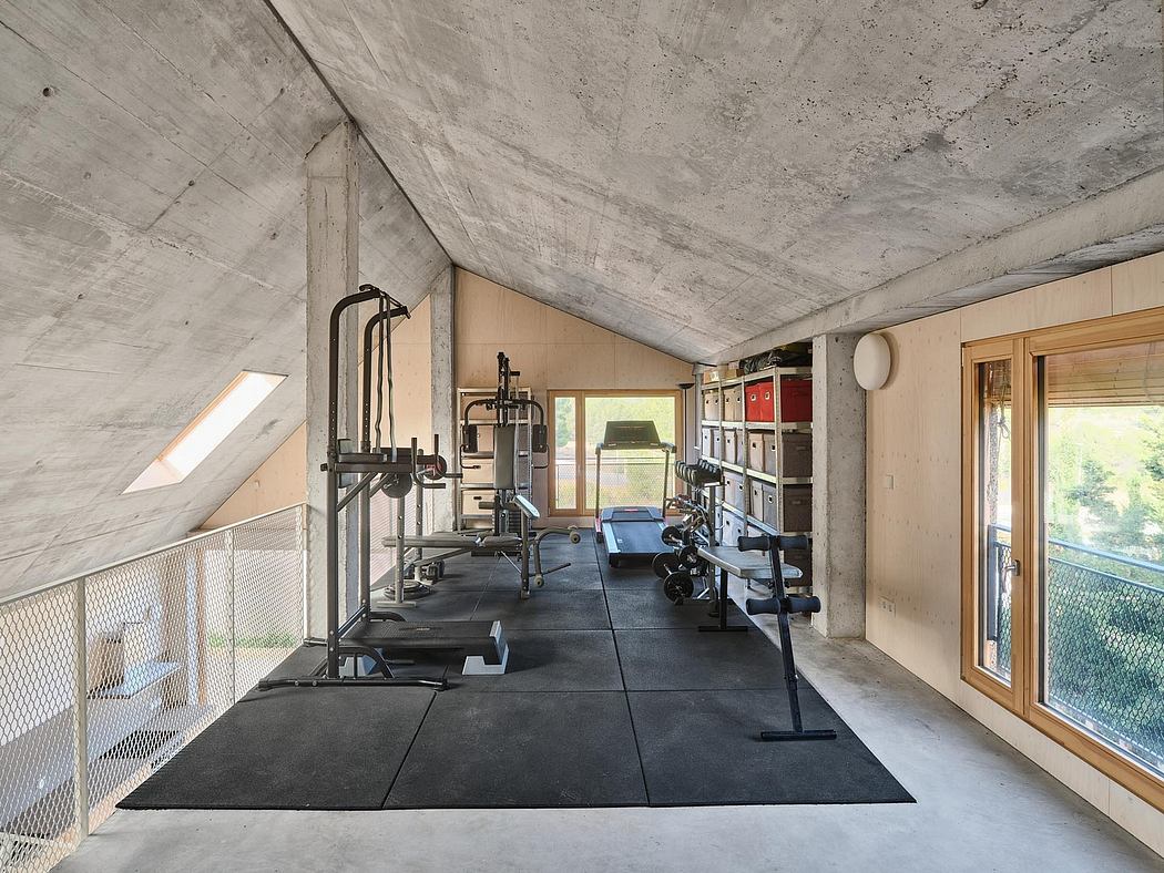 Minimalist concrete gym interior with workout equipment and exposed structure.