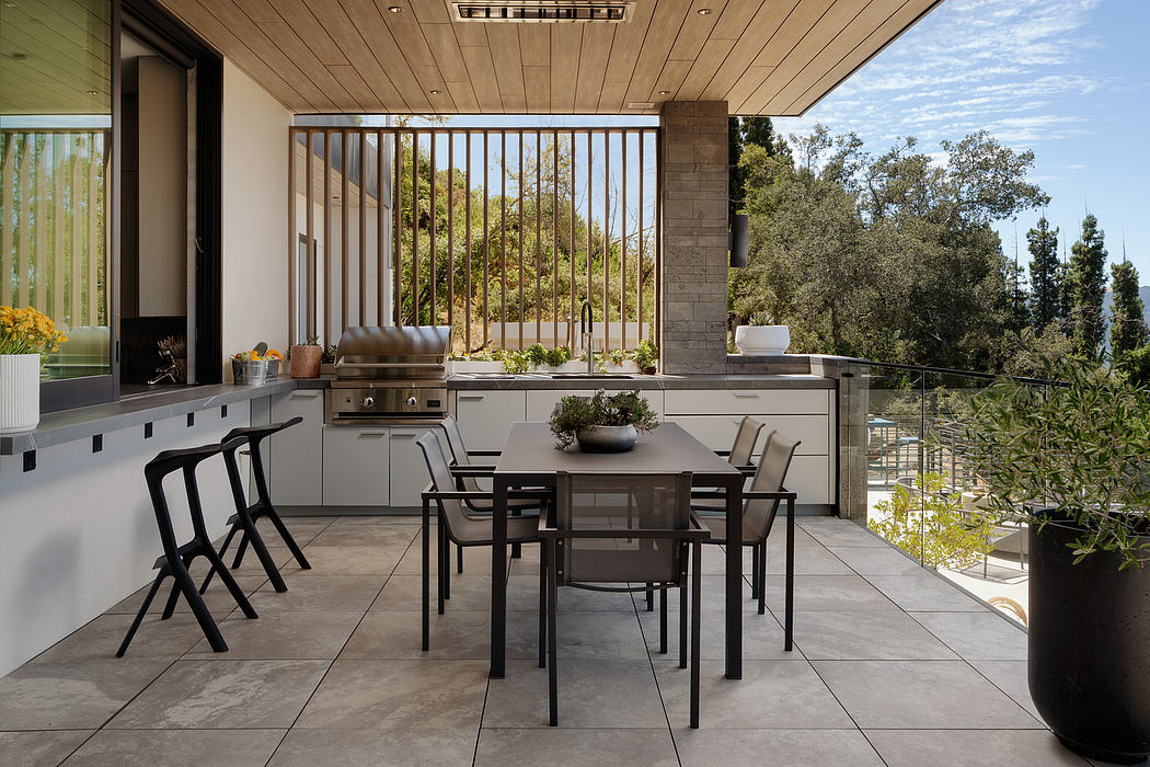 Outdoor kitchen with sleek, modern design surrounded by lush greenery.