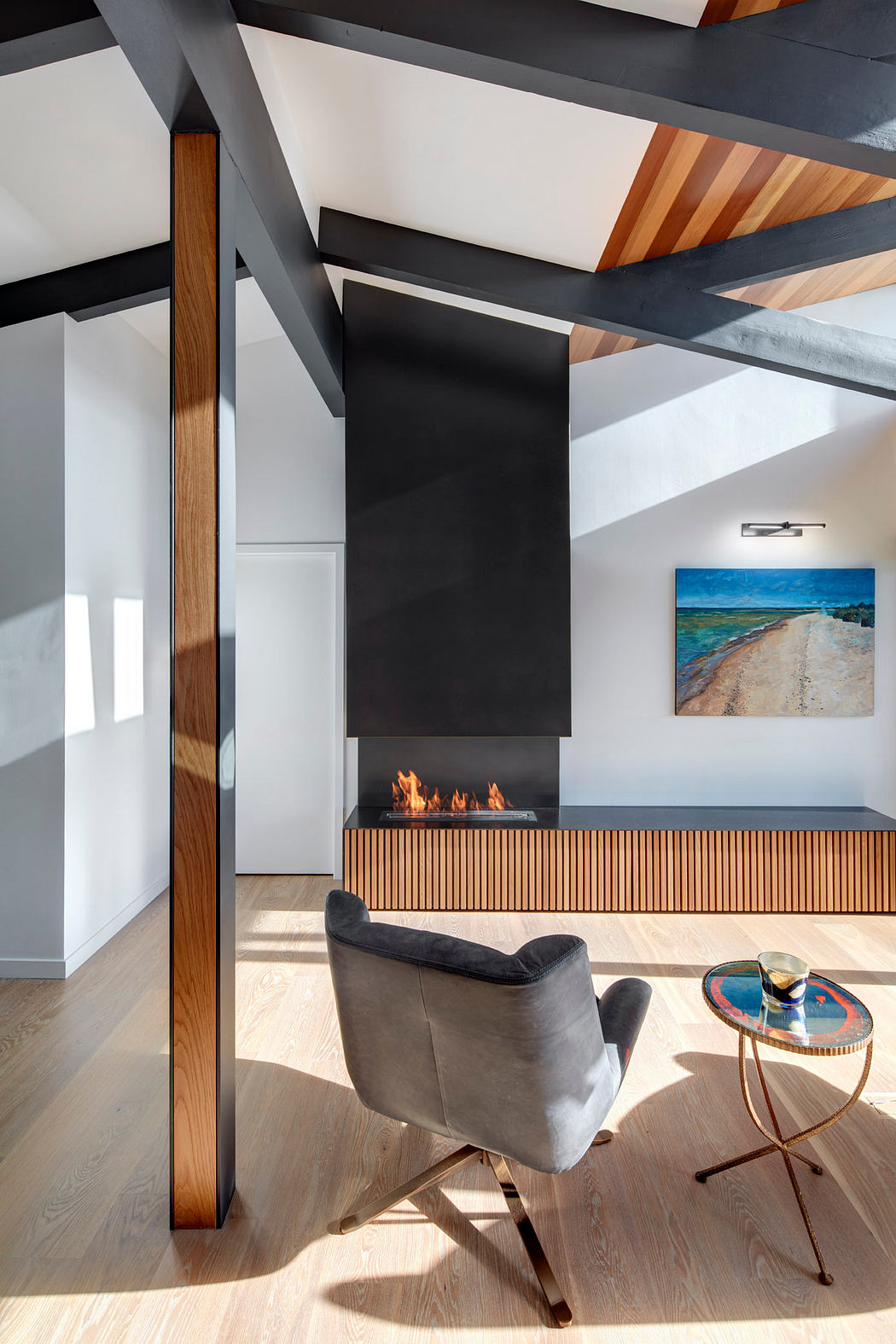 Minimalist living room with vaulted ceiling, fireplace, and modern furnishings.