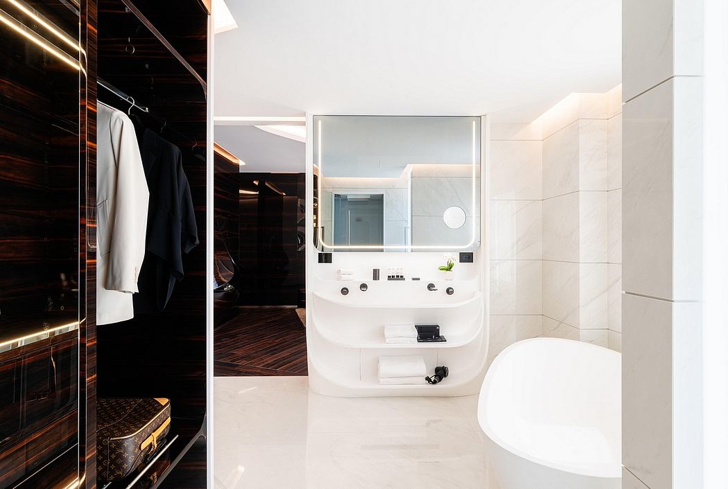 Modern bathroom with sleek white vanity and wooden closet space.