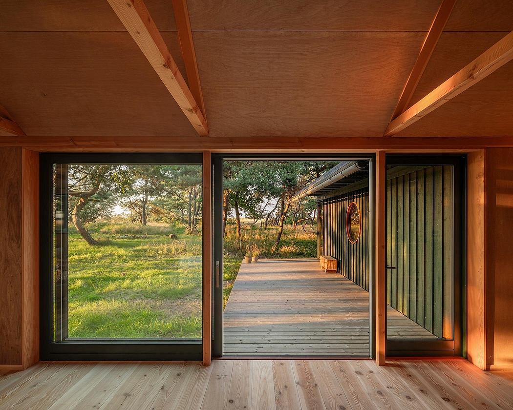 A rustic wooden cabin with floor-to-ceiling windows overlooking a lush outdoor scene.
