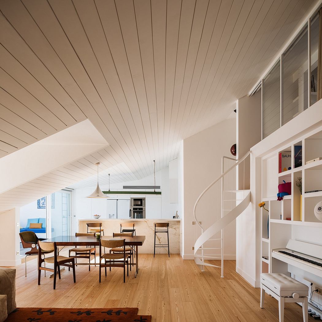A spacious, open-plan living and dining area with a wooden ceiling, clean lines, and minimal decor.