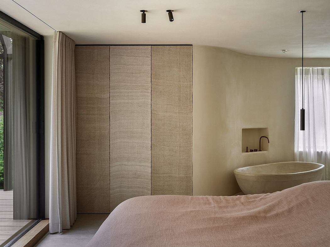 Minimalist bedroom with warm, natural tones, built-in storage, and a standalone tub.